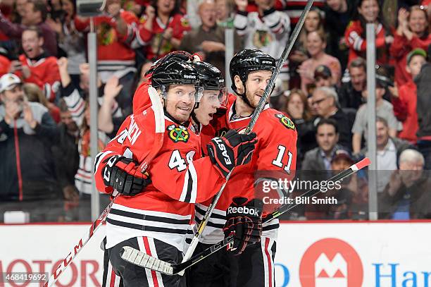 Kimmo Timonen, Teuvo Teravainen and Andrew Desjardins of the Chicago Blackhawks celebrate after Teravainen scored against the Vancouver Canucks in...