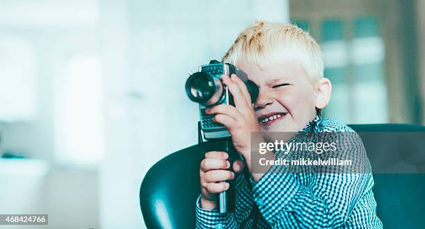 boy shoots a video with an old video camera - child film director stock pictures, royalty-free photos & images