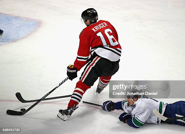 Marcus Kruger of the Chicago Blackhawks breaks the stick of Luca Sbisa of the Vancouver Canucks on his way to scoring a third period goal at the...