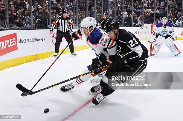 Dustin Brown of the Los Angeles Kings handles the puck against Keith Aulie of the Edmonton Oilers at STAPLES Center on April 02, 2015 in Los Angeles,...