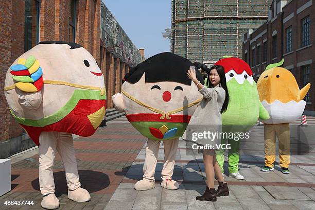 Girl takes a "selfie" with the mascots of Expo Milano on April 2, 2015 in Shanghai, China. The 2015 Expo Milano China Roadshow Shanghai Station opens...