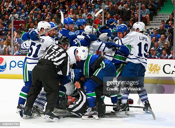 Linesman Jay Sharrers falls to the ice a the Toronto Maple Leafs and the Vancouver Canucks grapple during their NHL game at Rogers Arena March 14,...