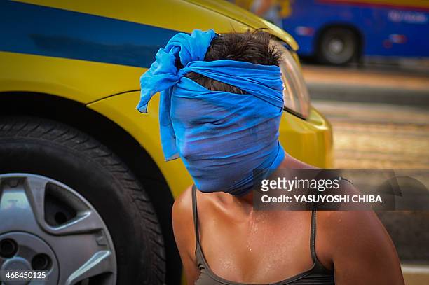 Woman wraps her face during a joint protest against a rise on public bus fares and the Brazil 2014 FIFA World Cup, in Rio de Janeiro, Brazil, on...
