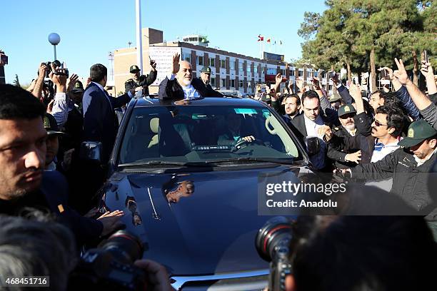 Iranian Foreign Minister Mohammad Javad Zarif greets people as nuclear negotiating committee arrive at Mehrabat Airport in Tehran on April 3 after...