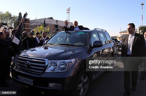 Iranian Foreign Minister Mohammad Javad Zarif greets people as nuclear negotiating committee arrive at Mehrabat Airport in Tehran on April 3 after...