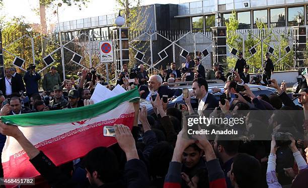 Iranian Foreign Minister Mohammad Javad Zarif greets people as nuclear negotiating committee arrive at Mehrabat Airport in Tehran on April 3 after...
