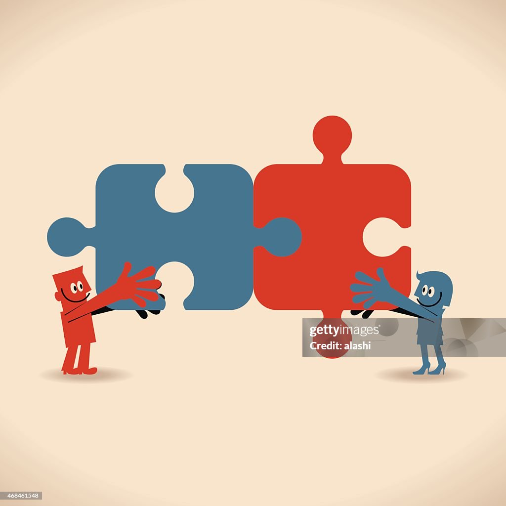 Smiling business man and woman with matching jigsaw puzzle pieces