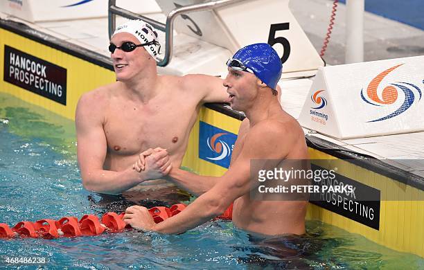 Dual Olympic champion Grant Hackett shakes hands with winner Mack Horton after finishing third in the 400-metres freestyle final in his comeback swim...