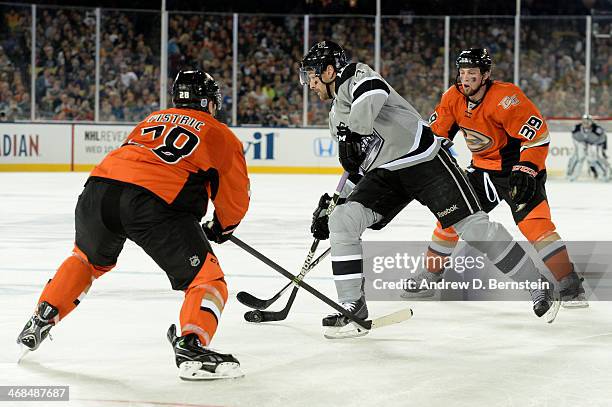 Justin Williams of the Los Angeles Kings skates with the puck against Mark Fistric and Matt Beleskey of the Anaheim Ducks during the 2014 Coors Light...