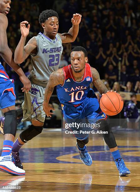 Guard Naadir Tharpe of the Kansas Jayhawks drives past guard Nigel Johnson of the Kansas State Wildcats during the first half on February 10, 2014 at...