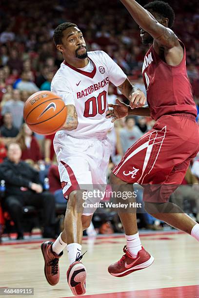 Rashad Madden of the Arkansas Razorbacks makes a pass from under the basket against the Alabama Crimson Tide at Bud Walton Arena on February 5, 2014...