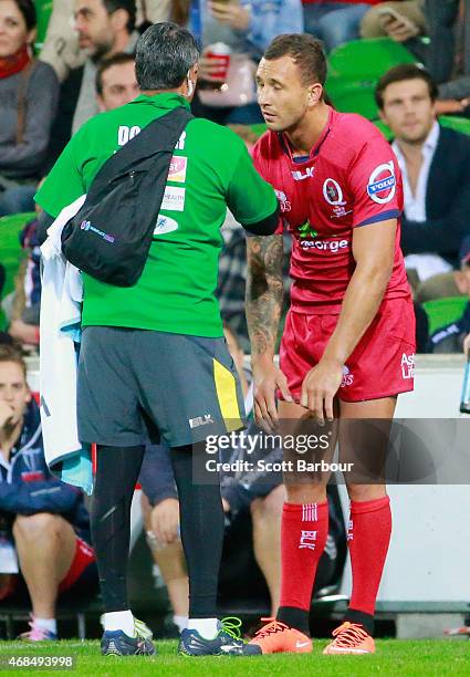 Quade Cooper of the Reds leaves the field in the 54th minute with a shoulder injury during the round eight Super Rugby match between the Rebels and...