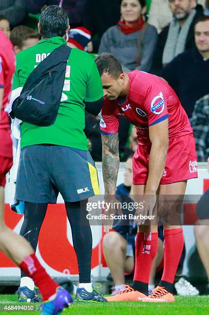 Quade Cooper of the Reds leaves the field in the 54th minute with a shoulder injury during the round eight Super Rugby match between the Rebels and...