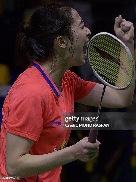 China's Wang Shixian celebrates after winning against Nozomi Okuhara of Japan during their women's quarter-final singles match at the 2015 Malaysia...