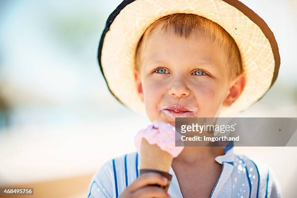 little boy eating ice cream. - straw hat stock pictures, royalty-free photos & images