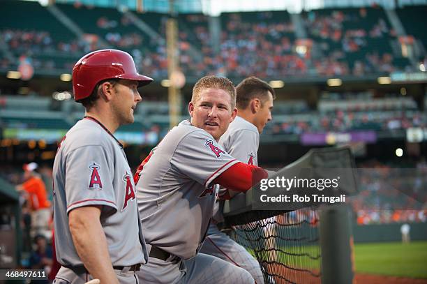 Mark Trumbo of the Los Angeles Angels talks in the dugout with Brendan Harris during the game against the Baltimore Orioles at Oriole Park at Camden...