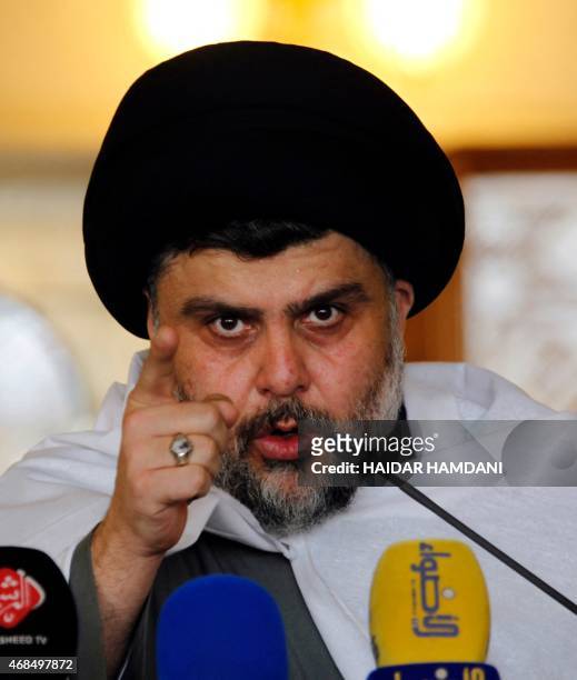 Iraqi Shiite cleric Moqtada al-Sadr gestures as he delivers a speech to his supporters following Friday prayers at the grand mosque of Kufa in the...