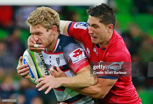 Bryce Hegarty of the Rebels is tackled by Anthony Faingaa of the Reds during the round eight Super Rugby match between the Rebels and the Reds at...