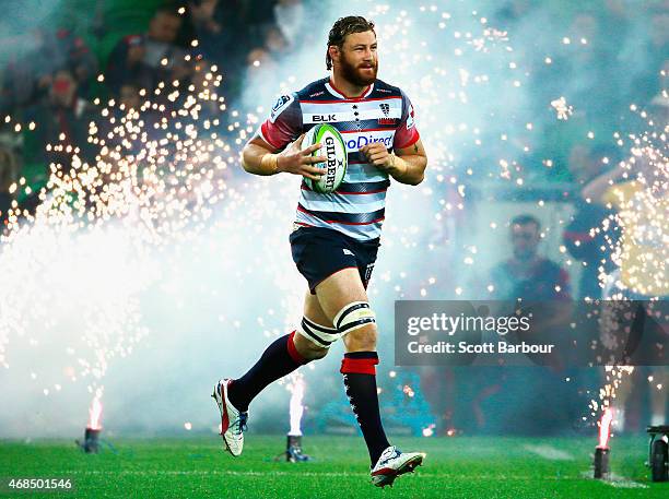 Scott Higginbotham of the Rebels leads the Rebels onto the field through fireworks during the round eight Super Rugby match between the Rebels and...
