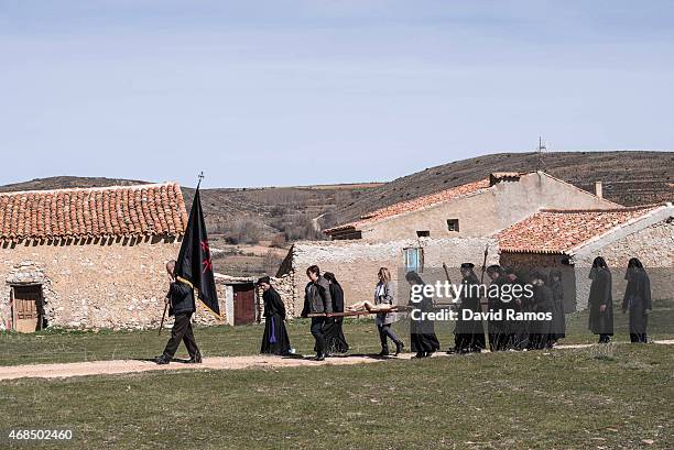 Worshippers of the brotherhood of 'La Cofadria de la Vera Cruz y El Cristo de las Lluvias' walk the way of the cross or 'Via Crucis' in Alustante on...