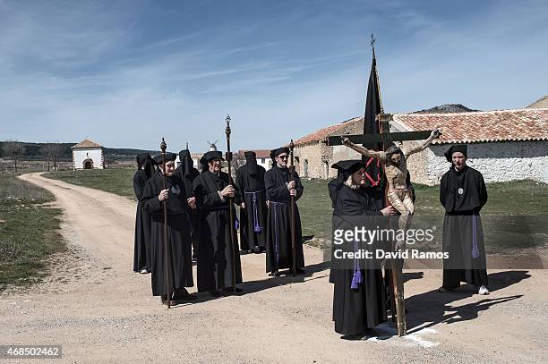 Worshippers of the brotherhood of 'La Cofadria de la Vera Cruz y El Cristo de las Lluvias' walk the way of the cross or 'Via Crucis' in Alustante on...