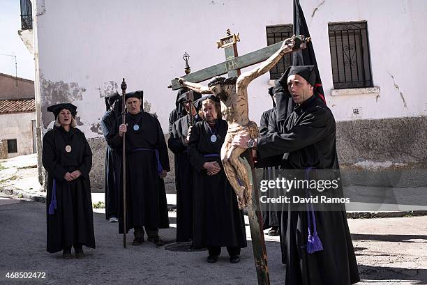 Worshippers of the brotherhood of 'La Cofadria de la Vera Cruz y El Cristo de las Lluvias' walk the way of the cross or 'Via Crucis' in Alustante on...