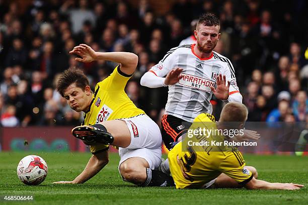 Ryan Tunnicliffe of Fulham is tackled by James Tarkowski and Jake Bidwell of Brentford during the Sky Bet Championship match between Fulham and...