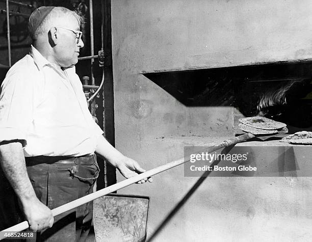 Myer Wool removes baked matzo from an oven used only for Passover, in Boston on March 28, 1945.