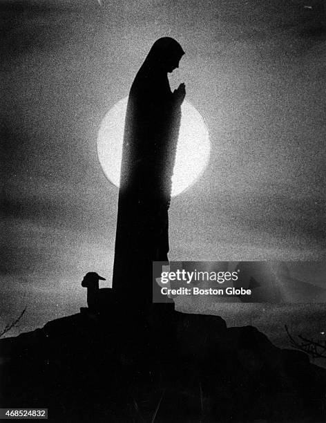 The sun rises behind a statue of Our Lady of Fatima at Ephpheta House, Oblate Fathers Retreat House in Cumberland, R.I on April 11, 1979.