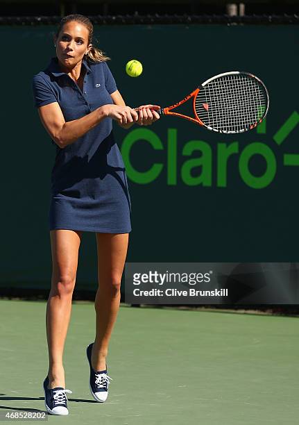 Sports Illustrated cover model Hannah Davis plays a backhand to Genie Bouchard of Canada as they have a hit during the Miami Open Presented by Itau...