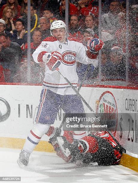 Alexei Emelin of the Montreal Canadiens hits Scott Gomez of the New Jersey Devils into the boards during the second period at the Prudential Center...