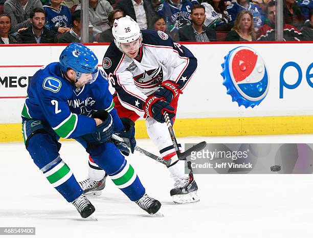 Dan Hamhuis of the Vancouver Canucks and Corey Tropp of the Columbus Blue Jackets watch the puck during their NHL game at Rogers Arena March 19, 2015...