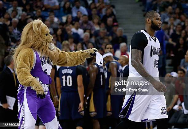 Slamson the Lion, the Sacramento Kings mascot, tries to give DeMarcus Cousins back his head band after it fell off during their game against the New...