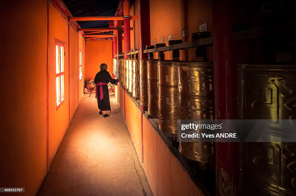 Woman turning prayer wheels in Tibet