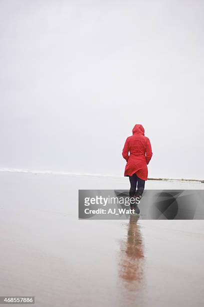 passeggiata sul mare in un giorno di pioggia - red coat foto e immagini stock
