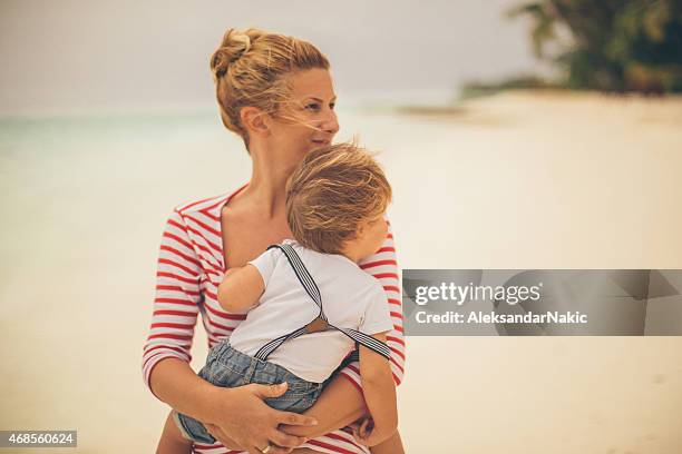 se siente seguro en mis manos de la madre - mothers day beach fotografías e imágenes de stock