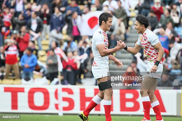 Yusaku Kuwazuru shakes hands with Chihito Matsui of Japan in the game between Samoa and Japan during the Tokyo Sevens Rugby 2015 on April 4, 2015 in...