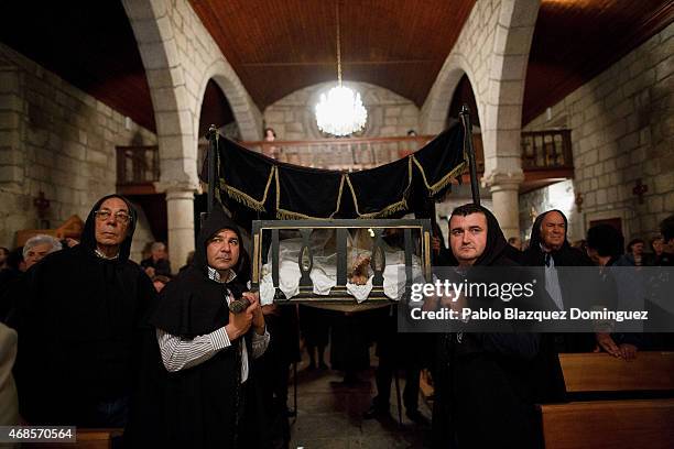 Members of the 'Santa Casa Misericordia' hold a float with an image of Jesus Christ during a procession on April 3, 2015 in Monsanto, in Idanha A...