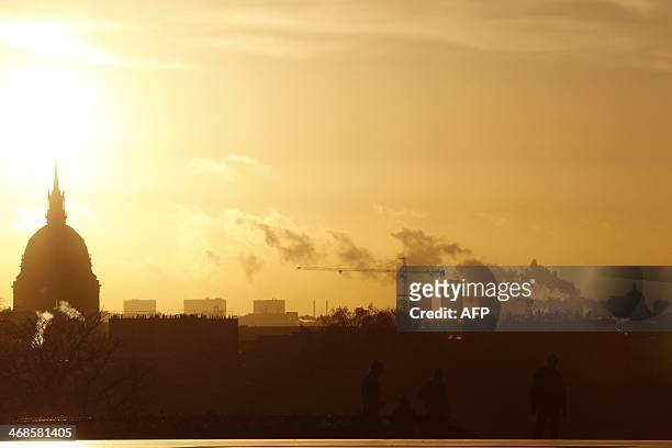 Picture taken on February 11, 2014 at sunrise on the Trocadero Esplanade, also known as the Parvis des droits de l'homme , shows people's silhouettes...