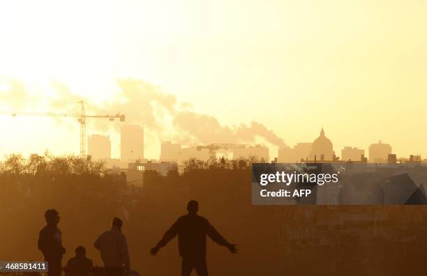 Picture taken on February 11, 2014 at sunrise on the Trocadero Esplanade, also known as the Parvis des droits de l'homme , shows people's silhouettes...