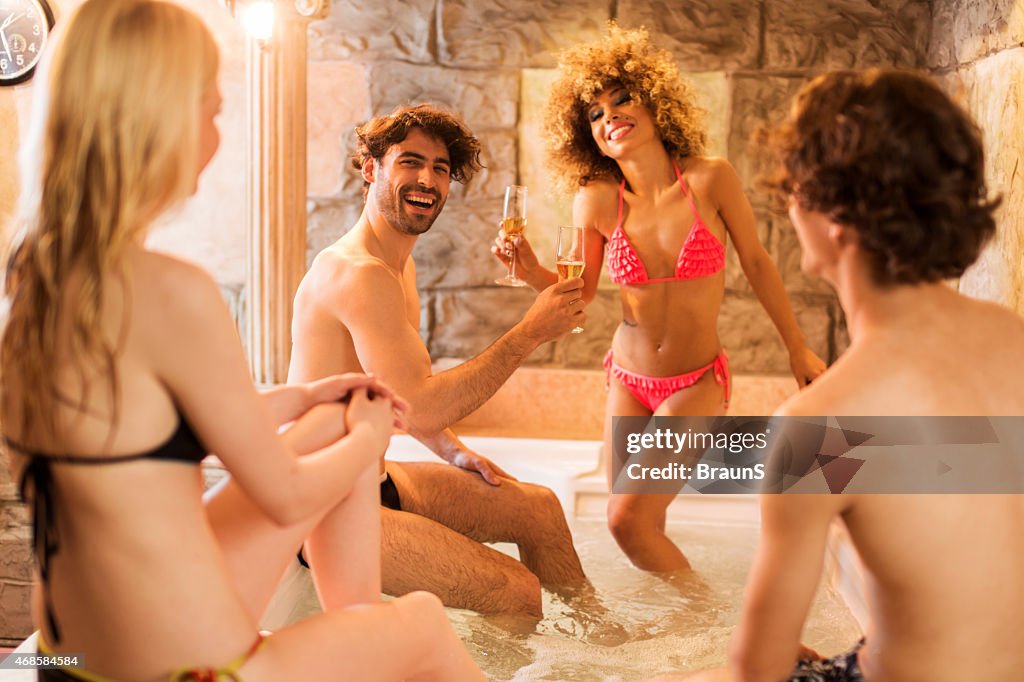 Young happy friends having fun in hot tub.