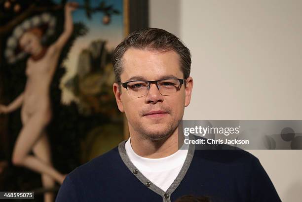 Actor Matt Damon poses in front of the painting 'Cupid Complaining to Venus' by Lucas Cranach the Elder as he attends a photocall for "The Monuments...