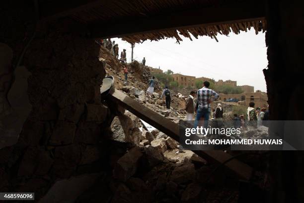 Yemenis inspect the rubble of destroyed houses in the village of Bani Matar, 70 kilometers West of Sanaa, on April 4 a day after it was reportedly...