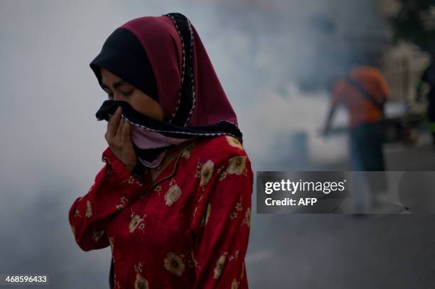 Malaysian pedestrian protects her face while engulfed in a cloud of pesticide during a dengue prevention spraying in Ampang, in the suburbs of Kuala...
