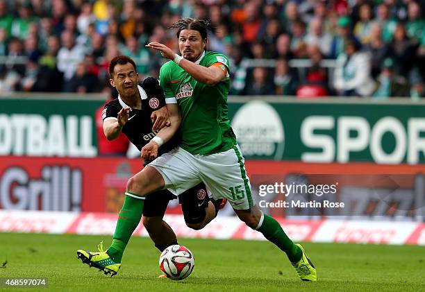 Sebastian Proedl of Bremen and Shinji Okazaki of Mainz battle for the ball during the Bundesliga match between SV Werder Bremen and 1. FSV Mainz 05...