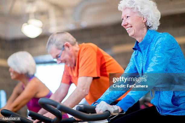 seniors exercising class - spin class men stock pictures, royalty-free photos & images