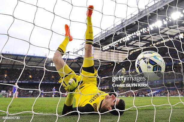Chelsea's Belgian goalkeeper Thibaut Courtois falls after failing to keep out a long range goal from Stoke City's Scottish midfielder Charlie Adam to...