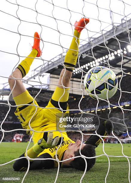 Chelsea's Belgian goalkeeper Thibaut Courtois falls into his own goal after chasing back but failing to keep out a long range shot from Stoke City's...