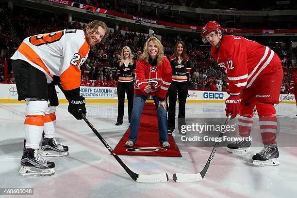 As a winner of the 30 Prizes in 30 Days promotion, Carolina Hurricanes season ticket holder Joanna Moore participates in a ceremonial puck drop with...