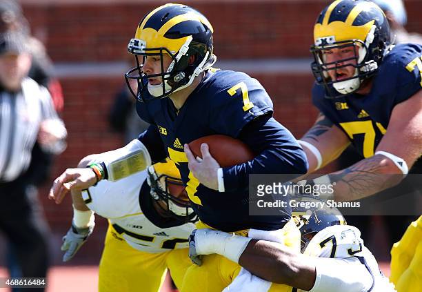 Shane Morris of the Michigan Wolverines tries to outrun Maurice Hurst during the Michigan Football Spring Game on April 4, 2015 at Michigan Stadium...